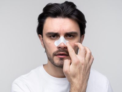 portrait-young-man-applying-nose-patch-min